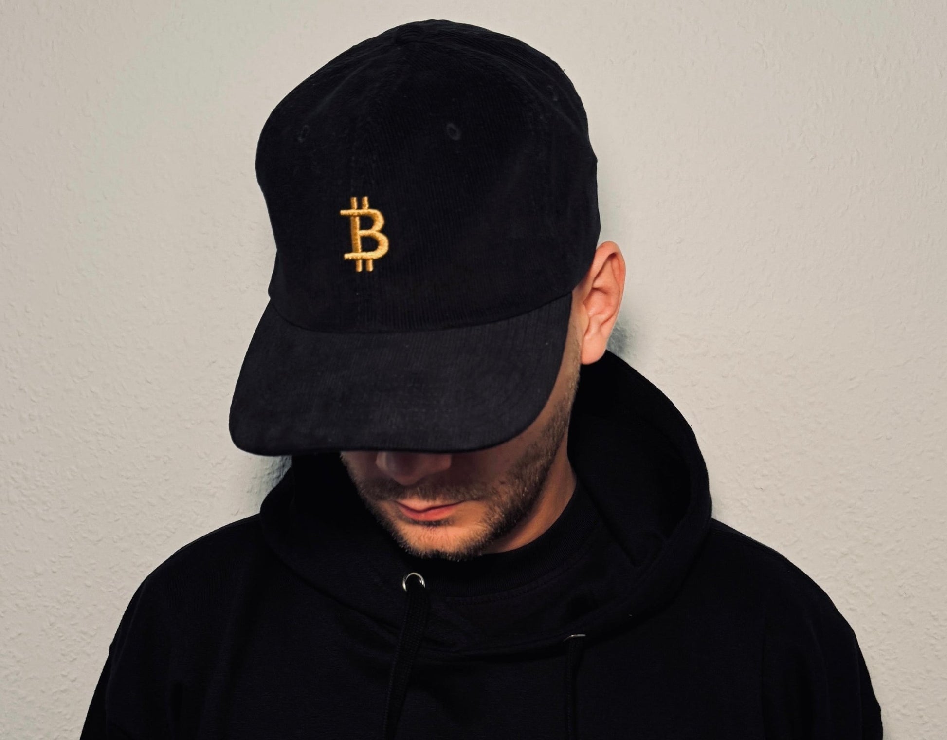 Bitcoin Kappe in schwarz. Goldener Stick mit Bitcoin Logo für Bitcoin Fans. Bitcoin Merchandising aus Deutschland.