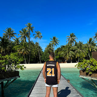Mann im 21M BITCOIN Basketball Trikot auf Steg vor tropischem Strand – Sommer-Vibes, Krypto-Lifestyle und Urlaubsfeeling