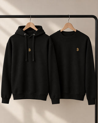 Schwarzer Bitcoin-Hoodie und Sweatshirt von BITVESTIS mit goldenem ₿-Stick an einer Kleiderstange.